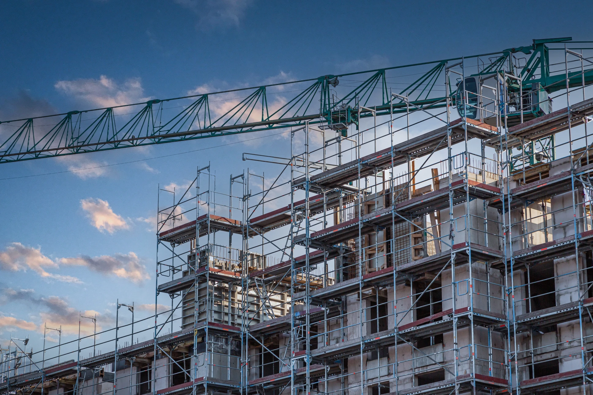 Chantier de construction résidentielle en cours avec plusieurs maisons individuelles à différents stades d'avancement