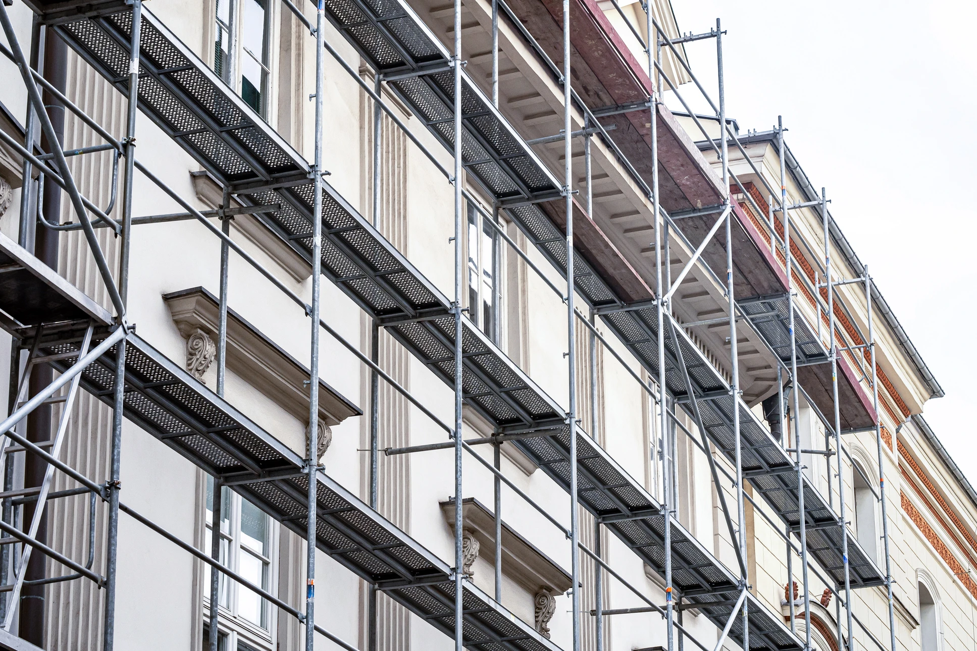 Façade de maison en rénovation avec échafaudage métallique tubulaire devant l'entrée